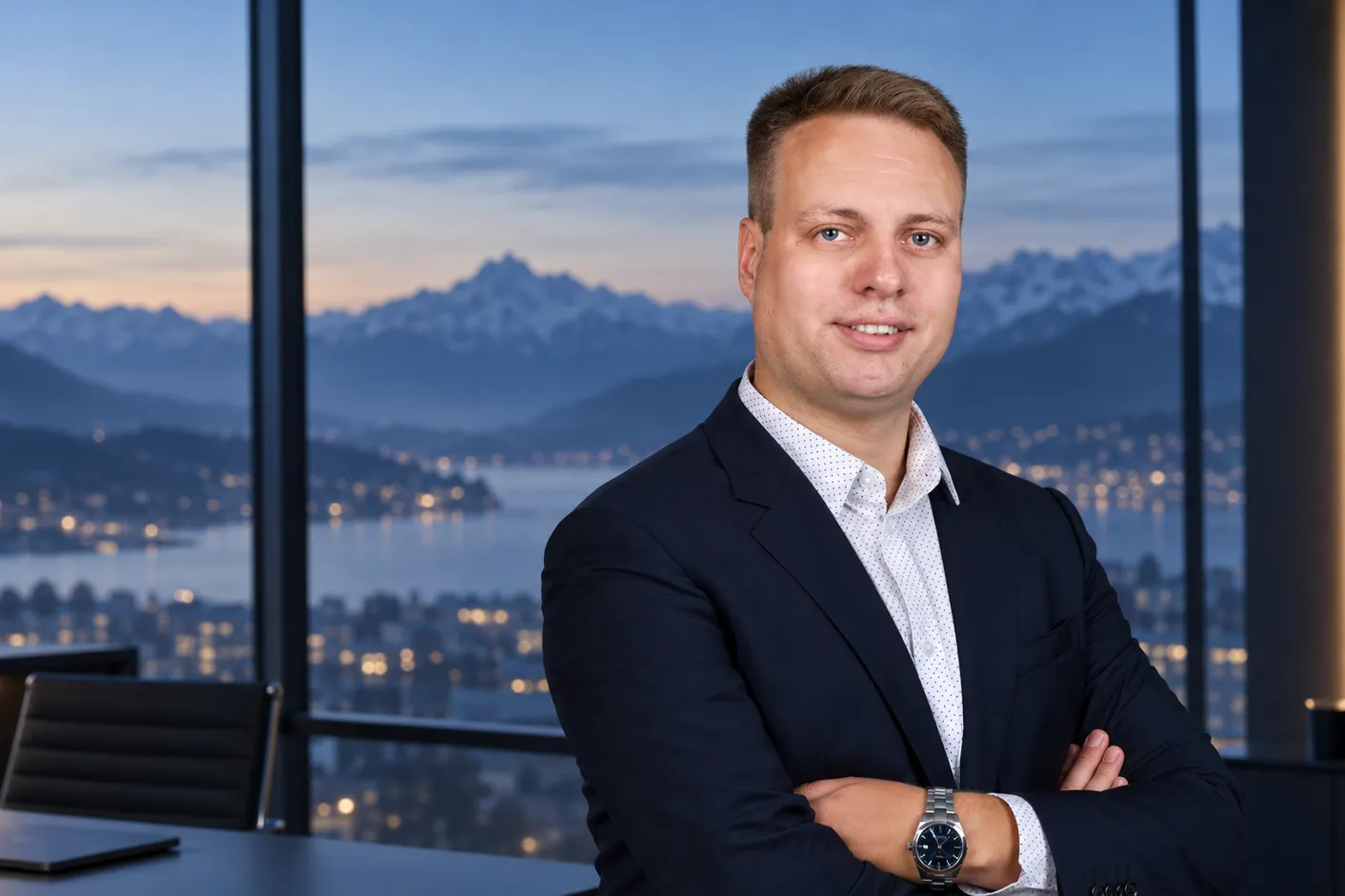 Nils Lappenbusch im Büro, im Hintergrund See und Alpen in der Abenddämmerung